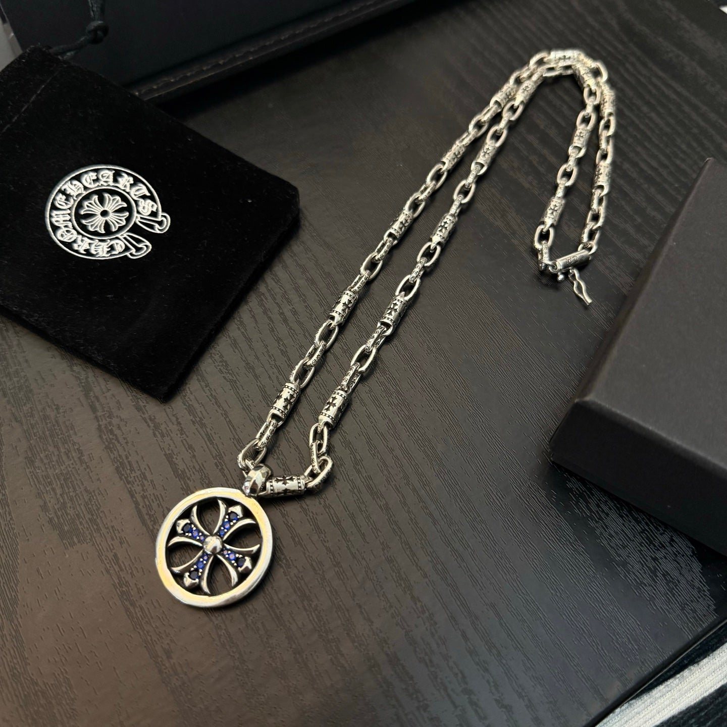 Chrome chain necklace with round medallion pendant featuring blue cross details