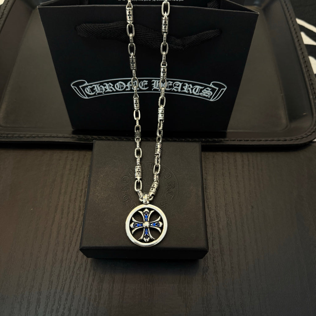 Chrome cross pendant necklace with blue accents in a round silver frame