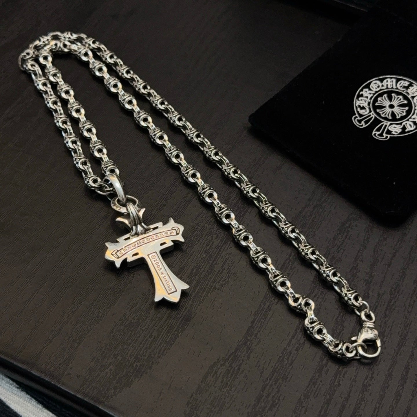 Chrome cross pendant necklace with ornate links and engraved charm