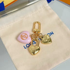 Gold heart keychain charms with pink heart charm on white pouch