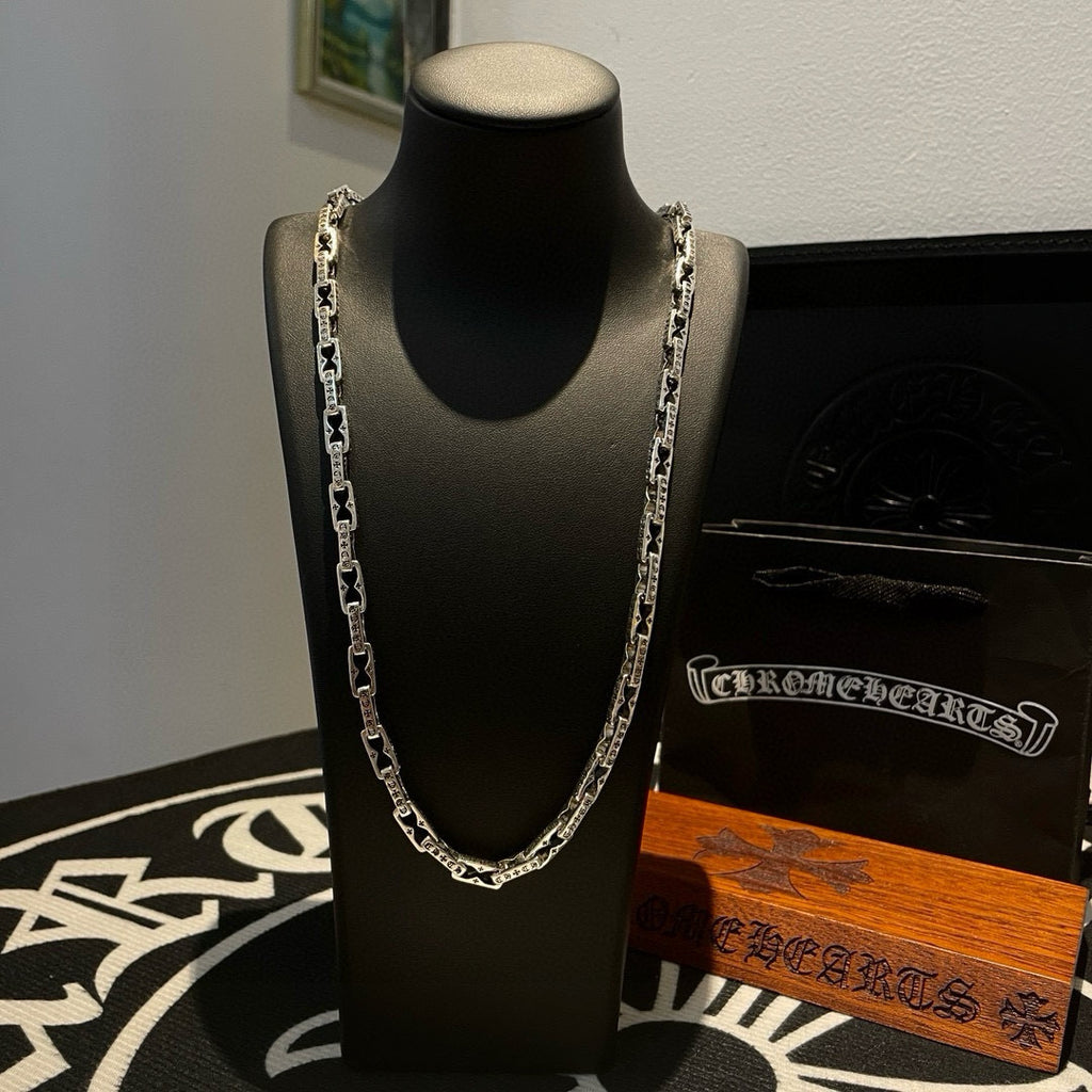 Silver chain necklace on black display stand with clasp visible at neckline