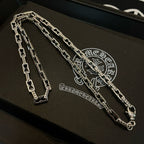 Silver chain necklace on jewelry box with ornate embossed emblem