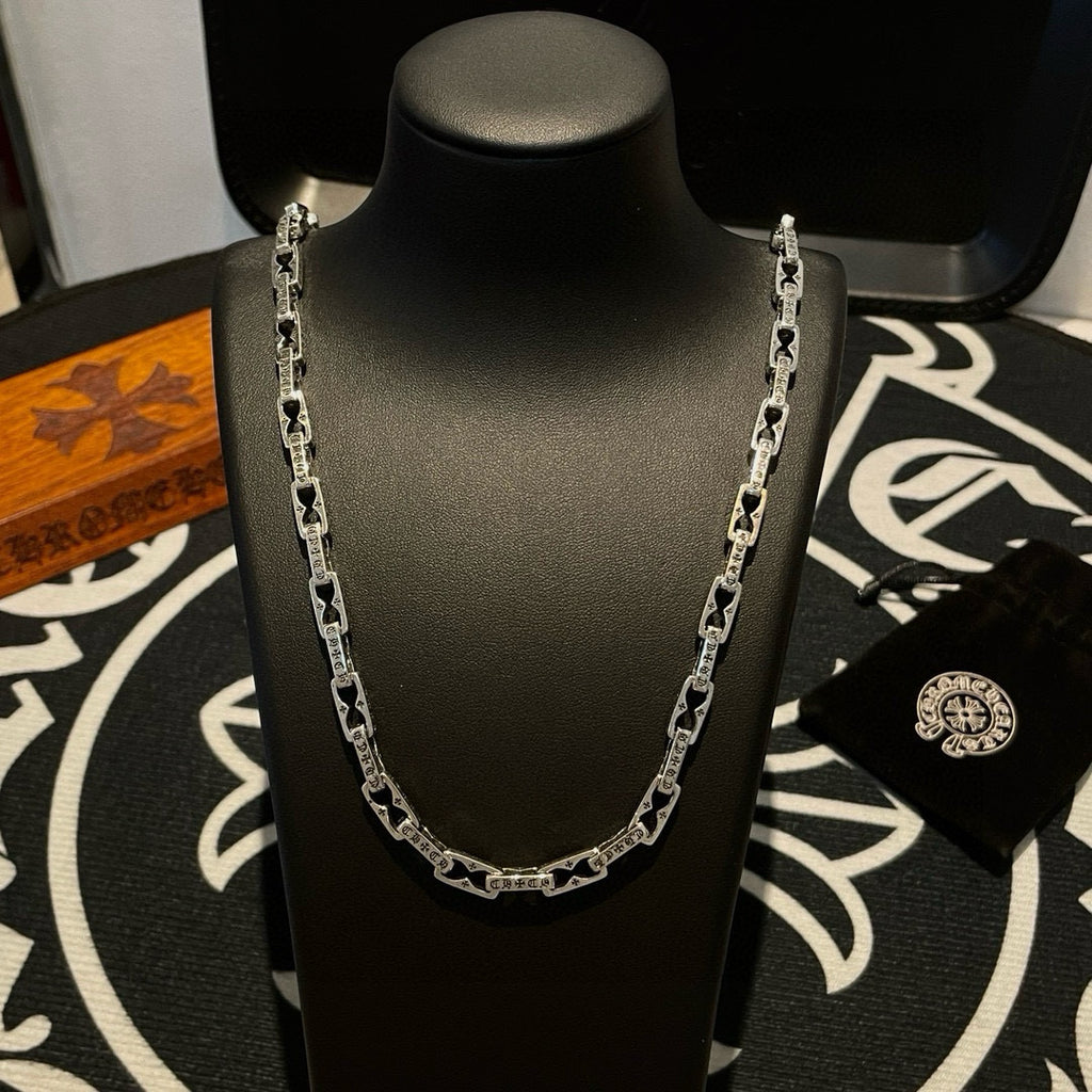 Silver chain necklace with linked pattern on dark mannequin bust