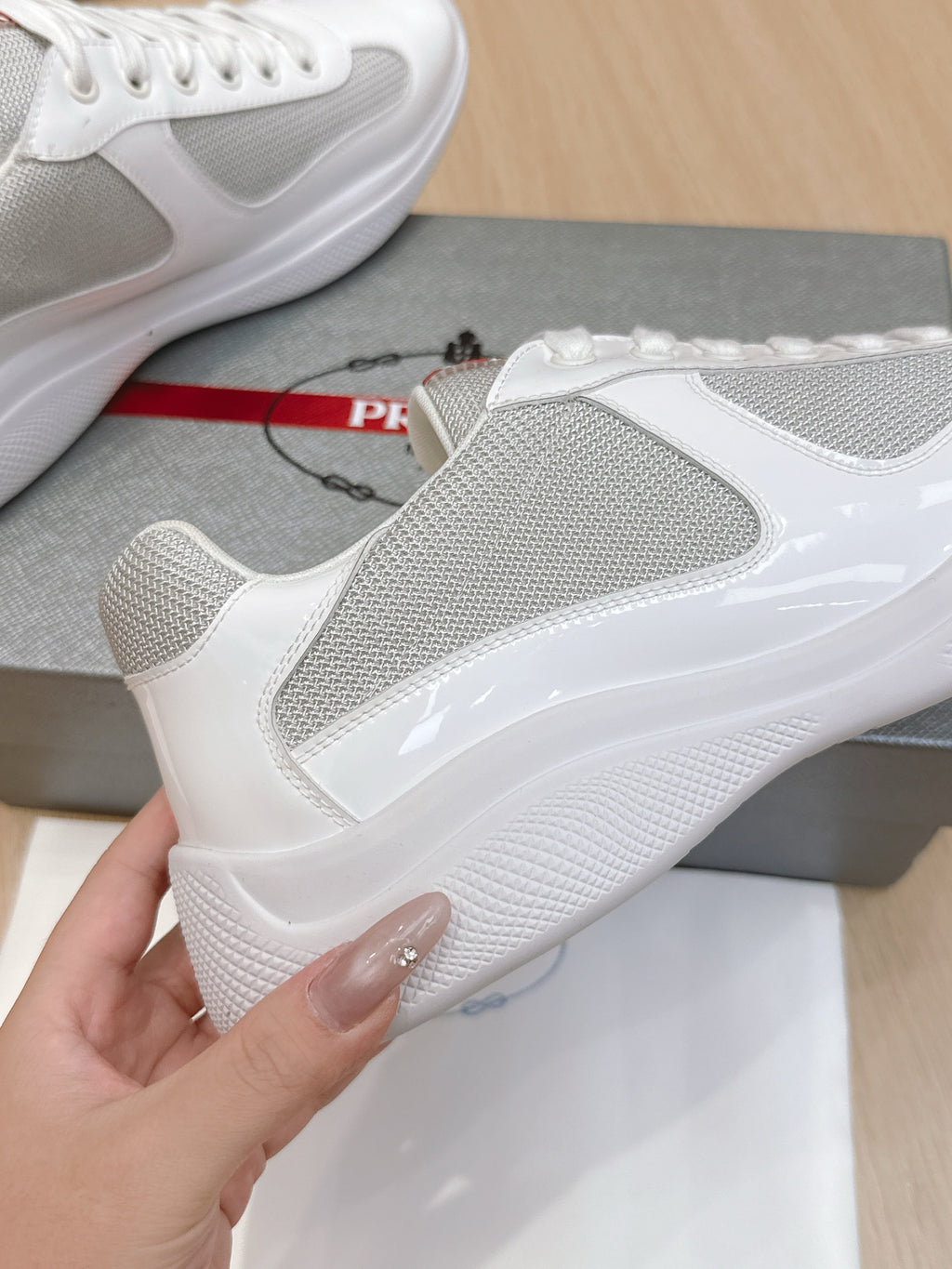 White sneaker side view with textured mesh panel and glossy quarter trim