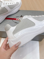 White sneaker side view with textured mesh panel and glossy quarter trim