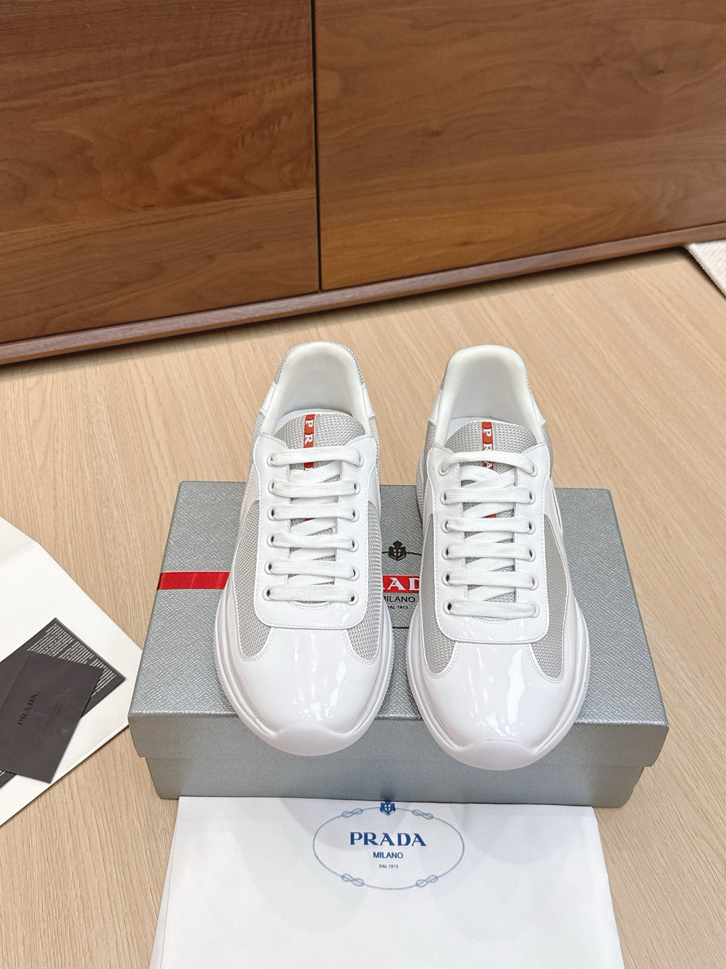 White lace-up sneaker with mesh upper and glossy toe cap