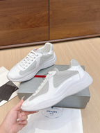 White low-top lace-up sneaker with red logo patch on the midsole