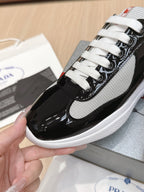 Prada unisex sneaker close-up: white mesh and black panels, white laces.