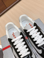 Prada unisex sneakers top view: black uppers with white laces.
