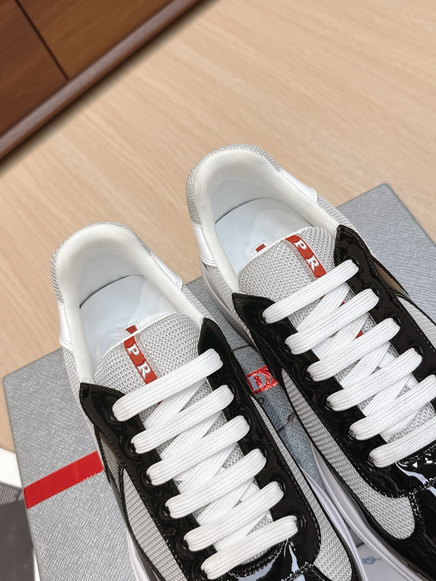 Prada unisex sneakers top view: black uppers with white laces.
