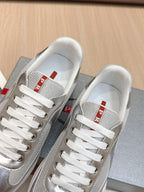 Prada unisex sneakers close-up, white laces with red-and-white tongue logo