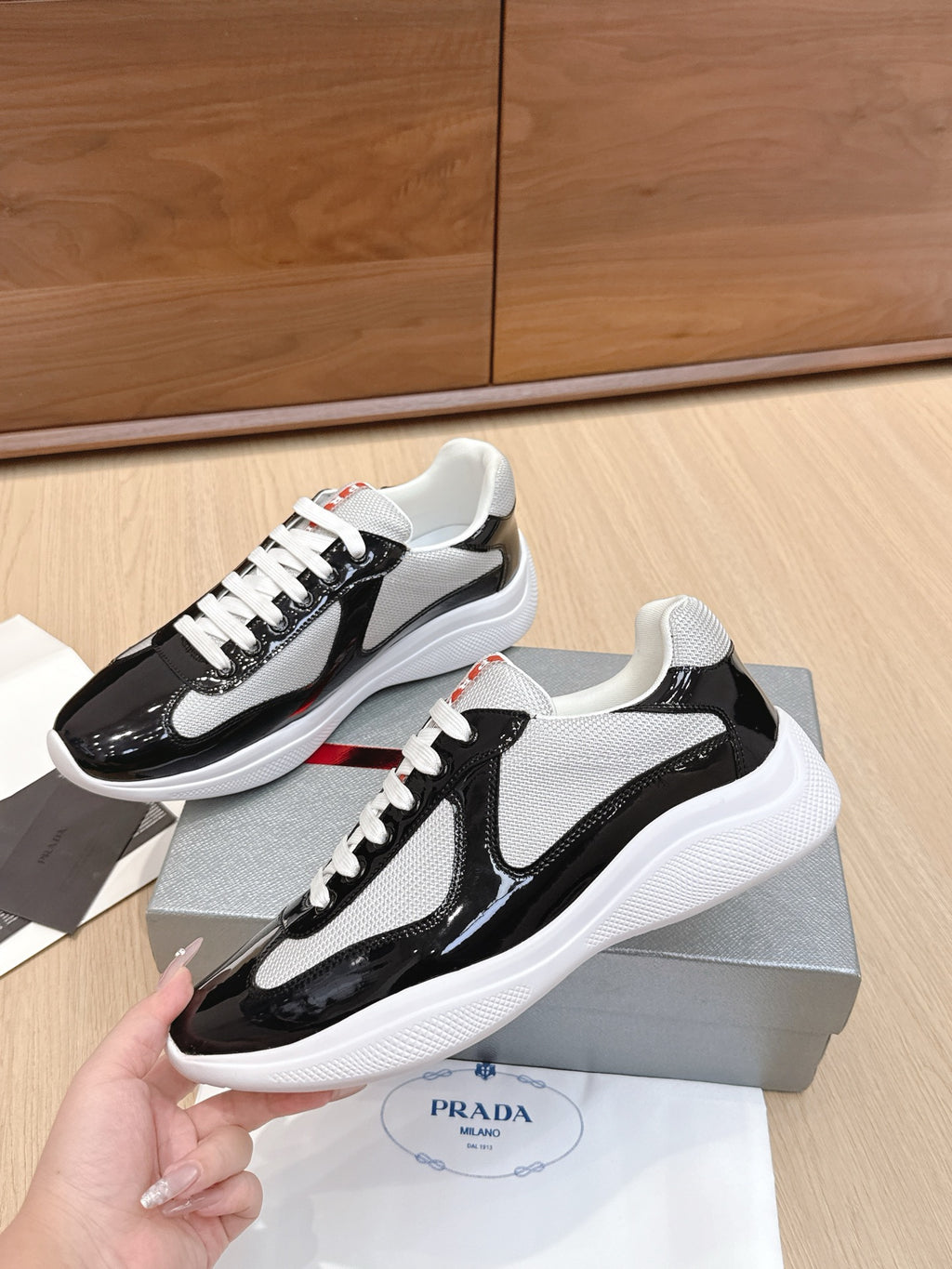 Prada unisex sneakers, two-tone black patent and gray mesh with white laces, side view