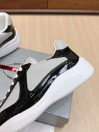 Prada unisex sneakers close side: black patent leather panel with white laces and sole