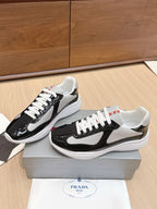 Prada unisex sneakers, angled view: black patent leather with white laces and gray mesh