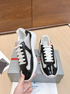 Prada unisex sneakers, front close-up: black glossy panels, white laces, white sole