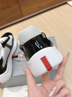 Prada unisex sneakers heel detail: black patent upper with white textured heel and red patch
