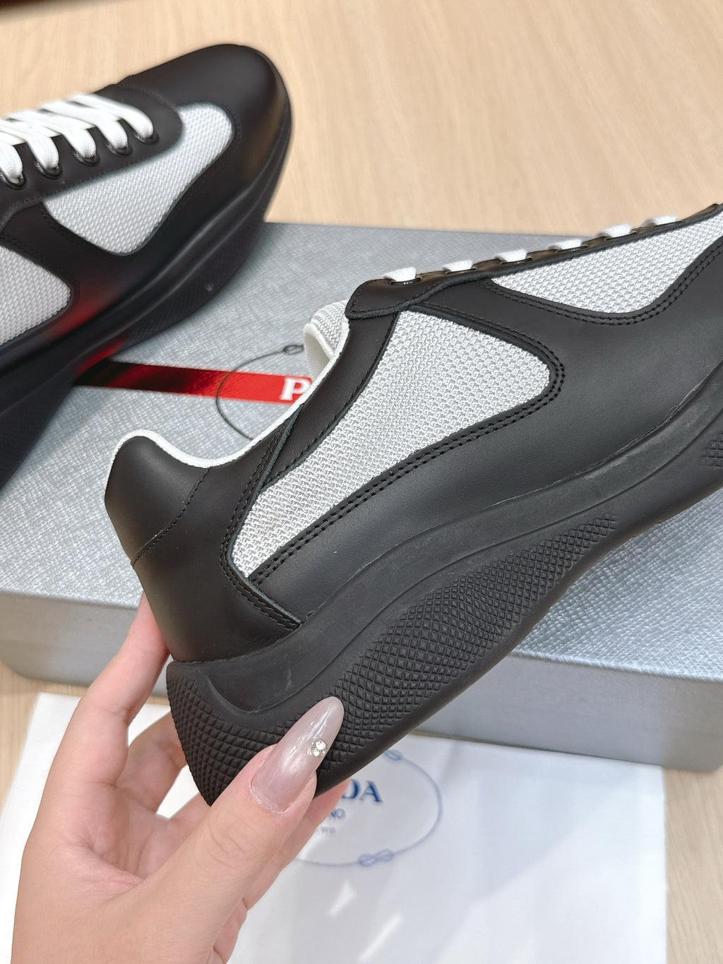 Prada unisex sneaker close-up of heel-side, black and grey panels with white trim