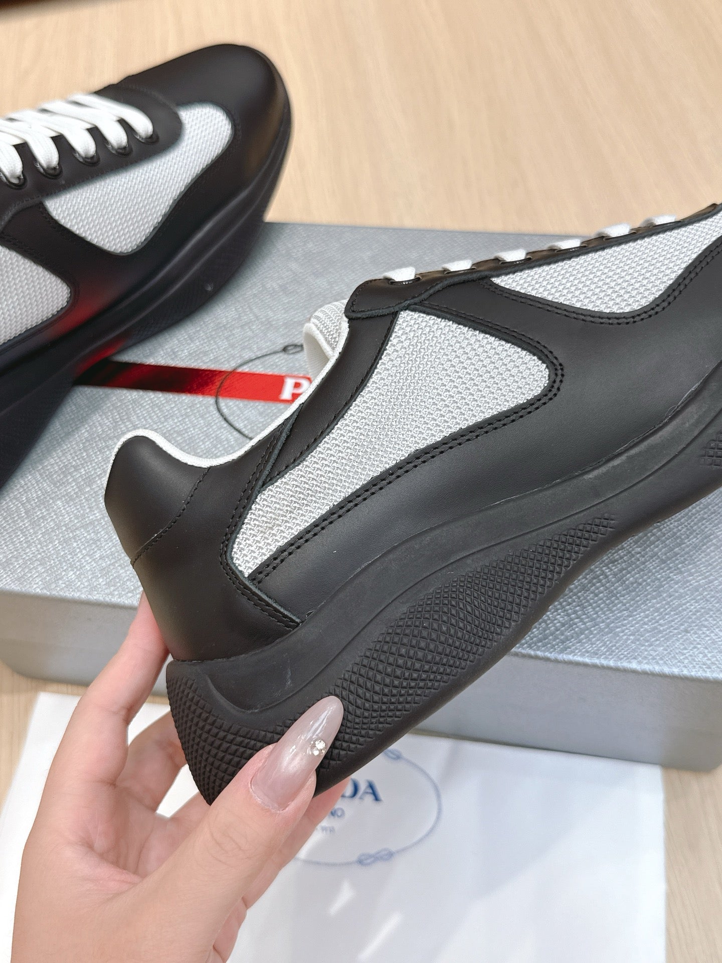 Prada unisex sneaker close-up of heel-side, black and grey panels with white trim
