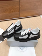 Prada unisex sneakers pair, black with white swoosh and lace-up front