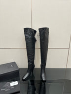 Knee-high black boots with pointed toe and stiletto heel, minimal side strap detail