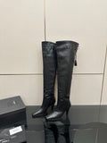 Knee-high black leather-look boots with pointed toe, high stiletto heel, tassel ties