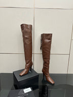 YSL knee-high leather boots, dark brown, front view pair on display boxes