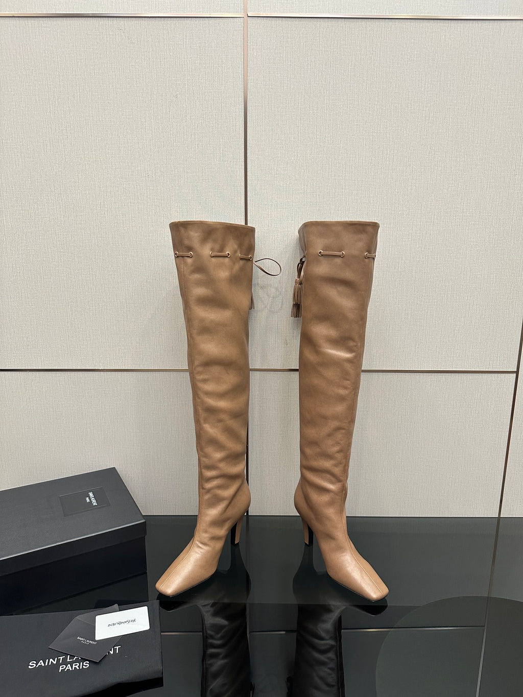 YSL taupe knee-high leather boots with stiletto heel, paired on display stand