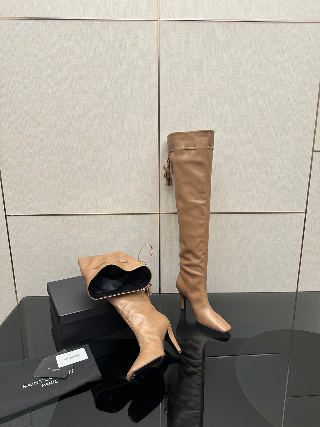 YSL taupe knee-high boot with stiletto heel, plus black slide-style shoe