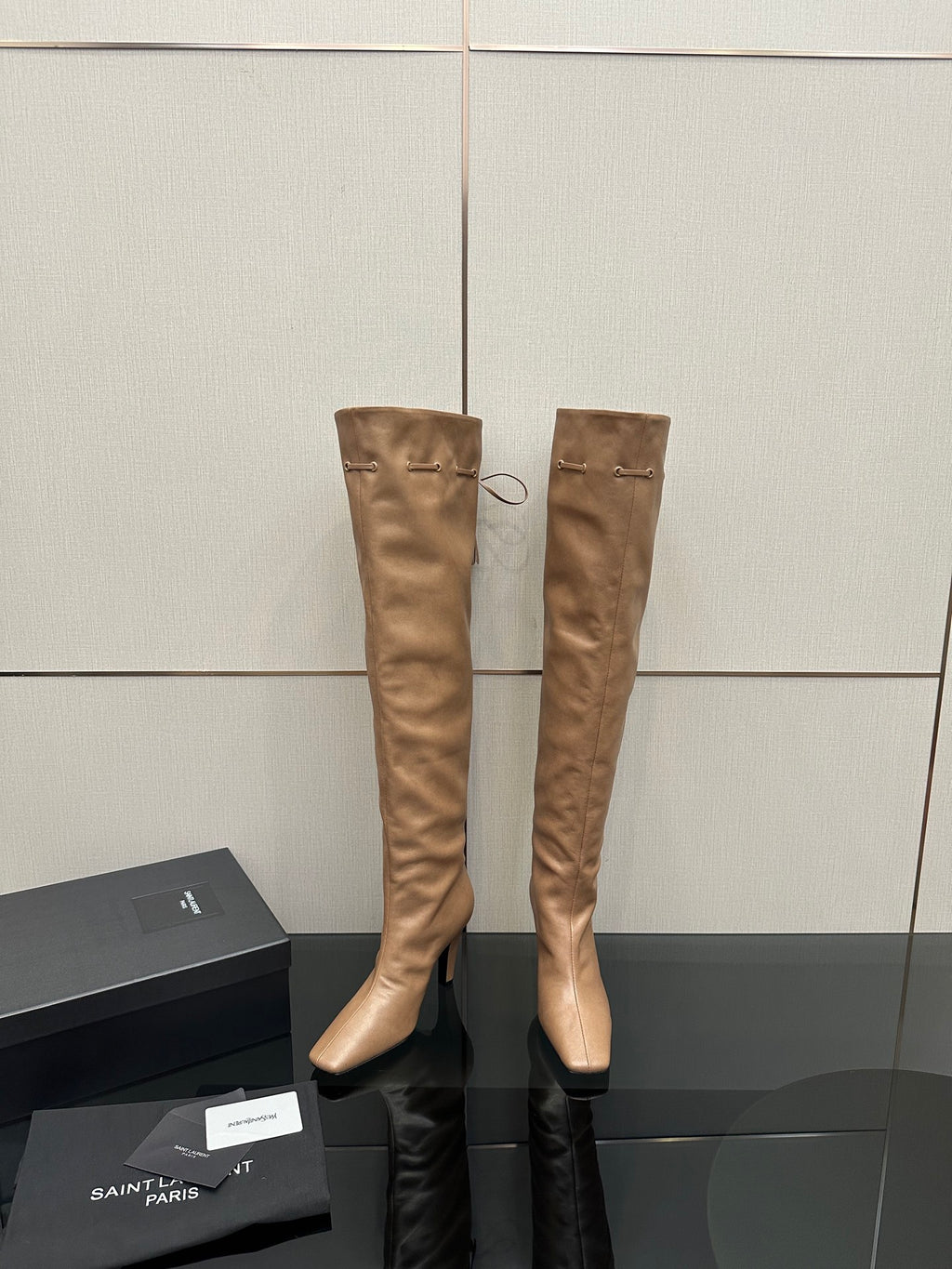 YSL taupe knee-high boots with stiletto heel and tassel tie detail, front view