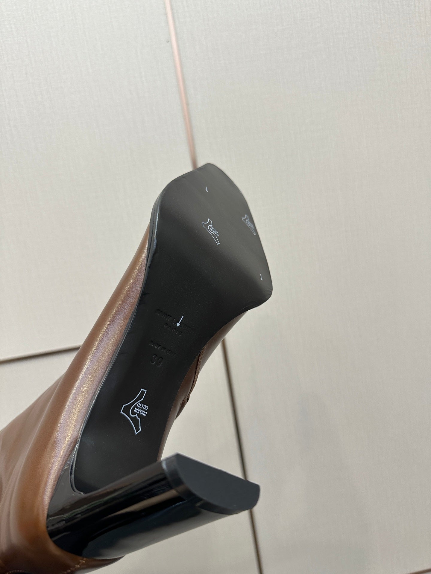 Brown leather boot sole and heel detail with logo print on inner lining