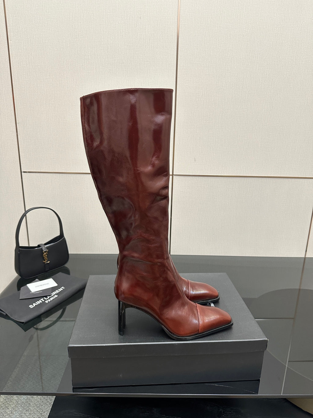 YSL ladies knee-high boots in dark burgundy glossy leather, side view on box