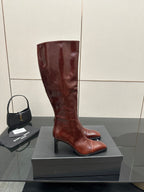 YSL ladies knee-high boots in dark burgundy glossy leather, side view on box