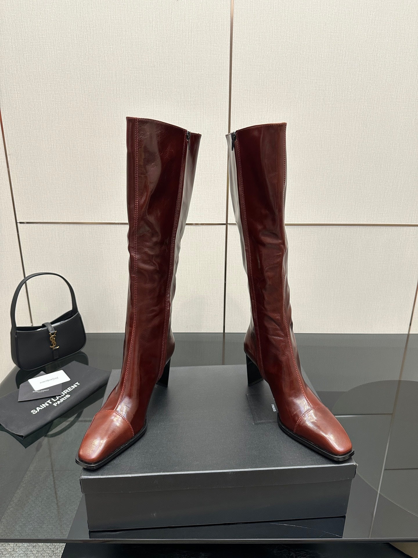 YSL ladies knee-high boots in dark burgundy glossy leather, front view with slim heel