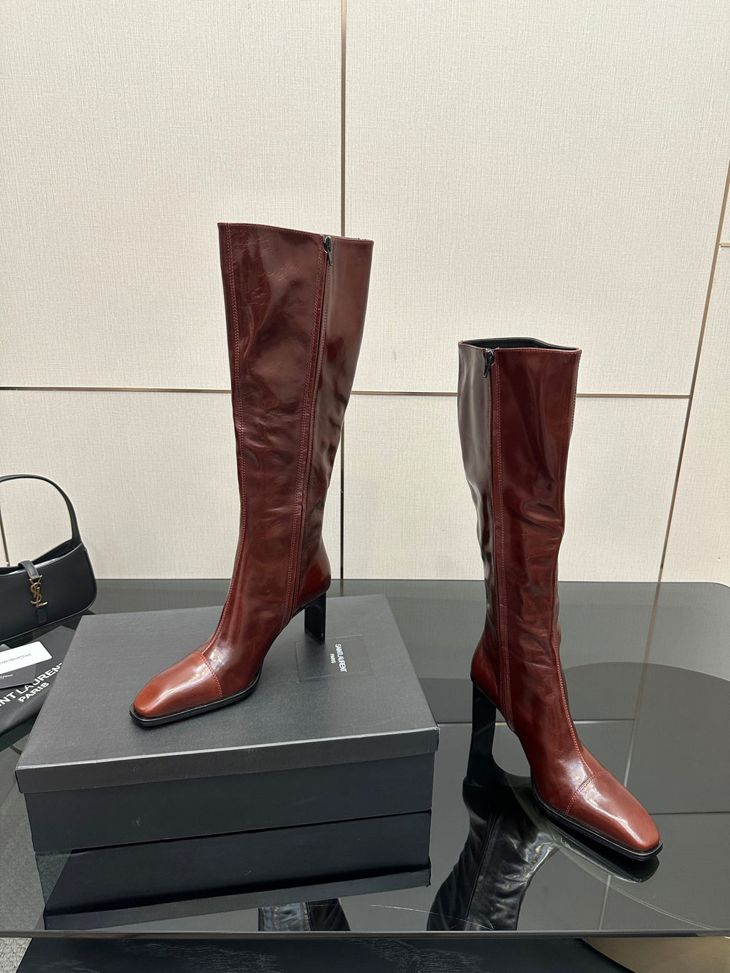 YSL ladies knee-high boots in dark burgundy glossy leather, curved heel profile