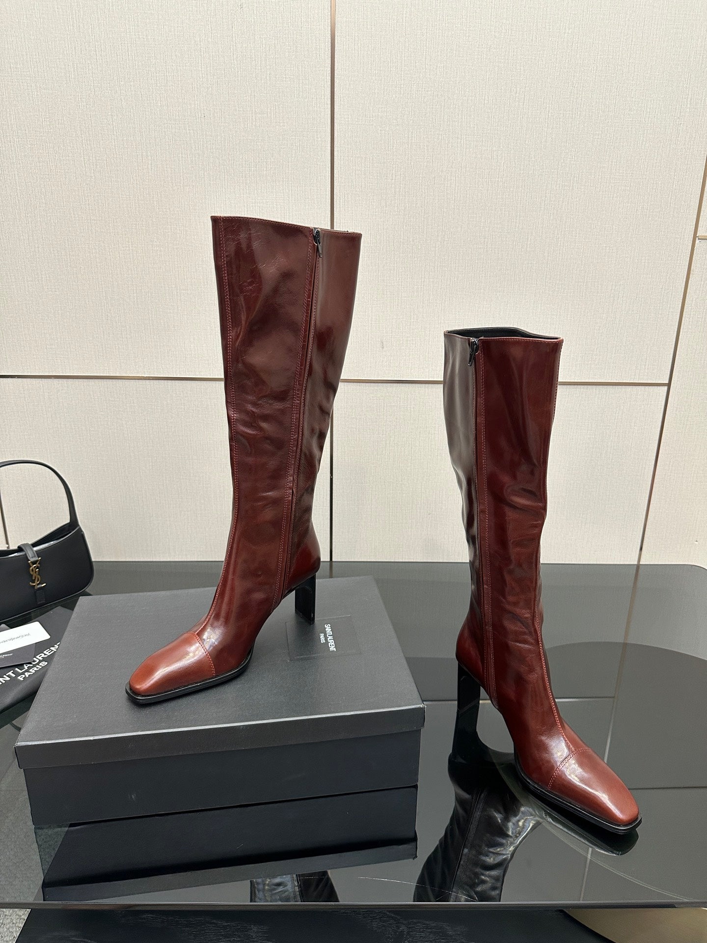 YSL ladies knee-high boots in dark burgundy glossy leather, curved heel profile