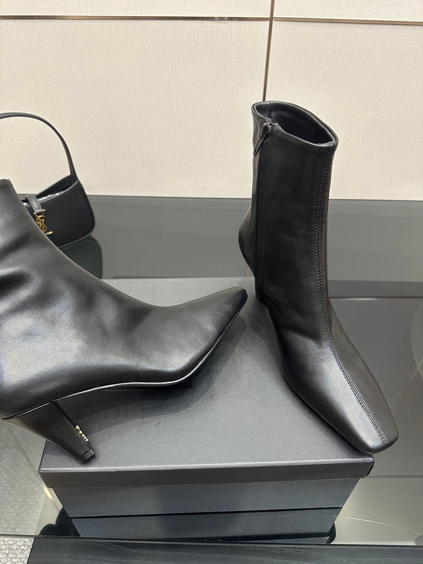 Close view of black ankle boots with block heels on a display box