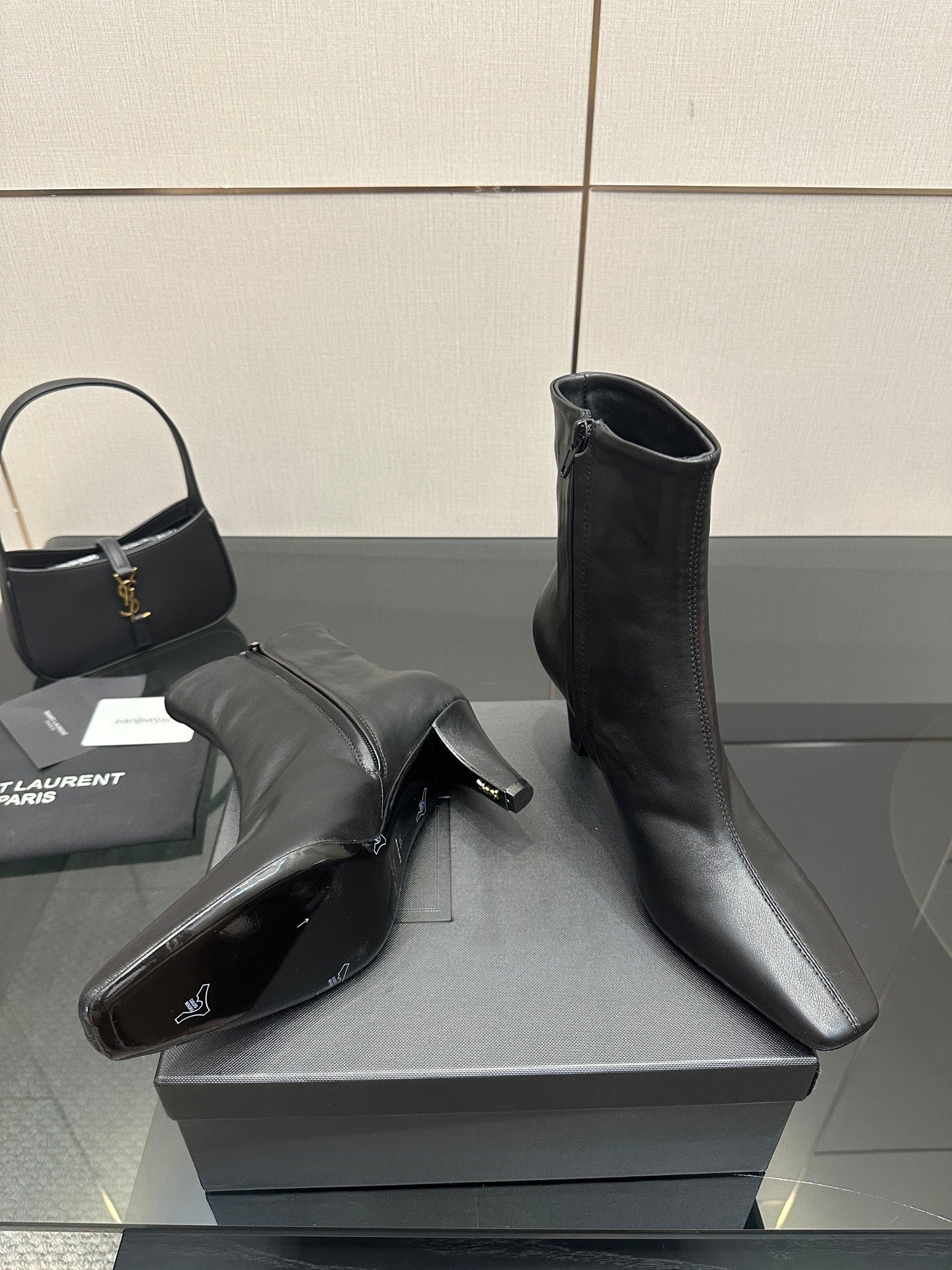 Black ankle boots with block heels on a display box