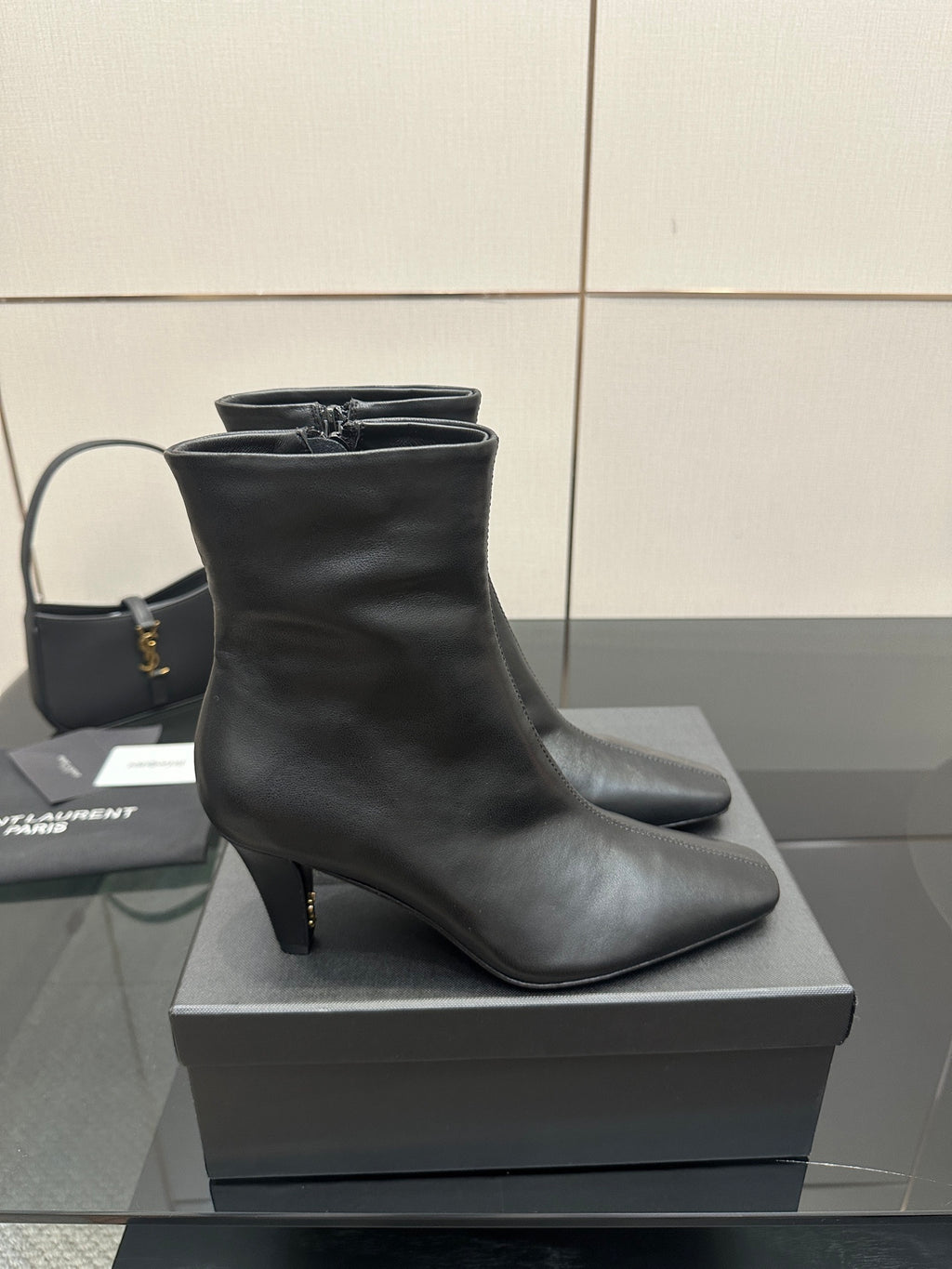Black heeled ankle boot on a display box
