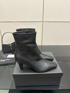 Black heeled ankle boot on a display box