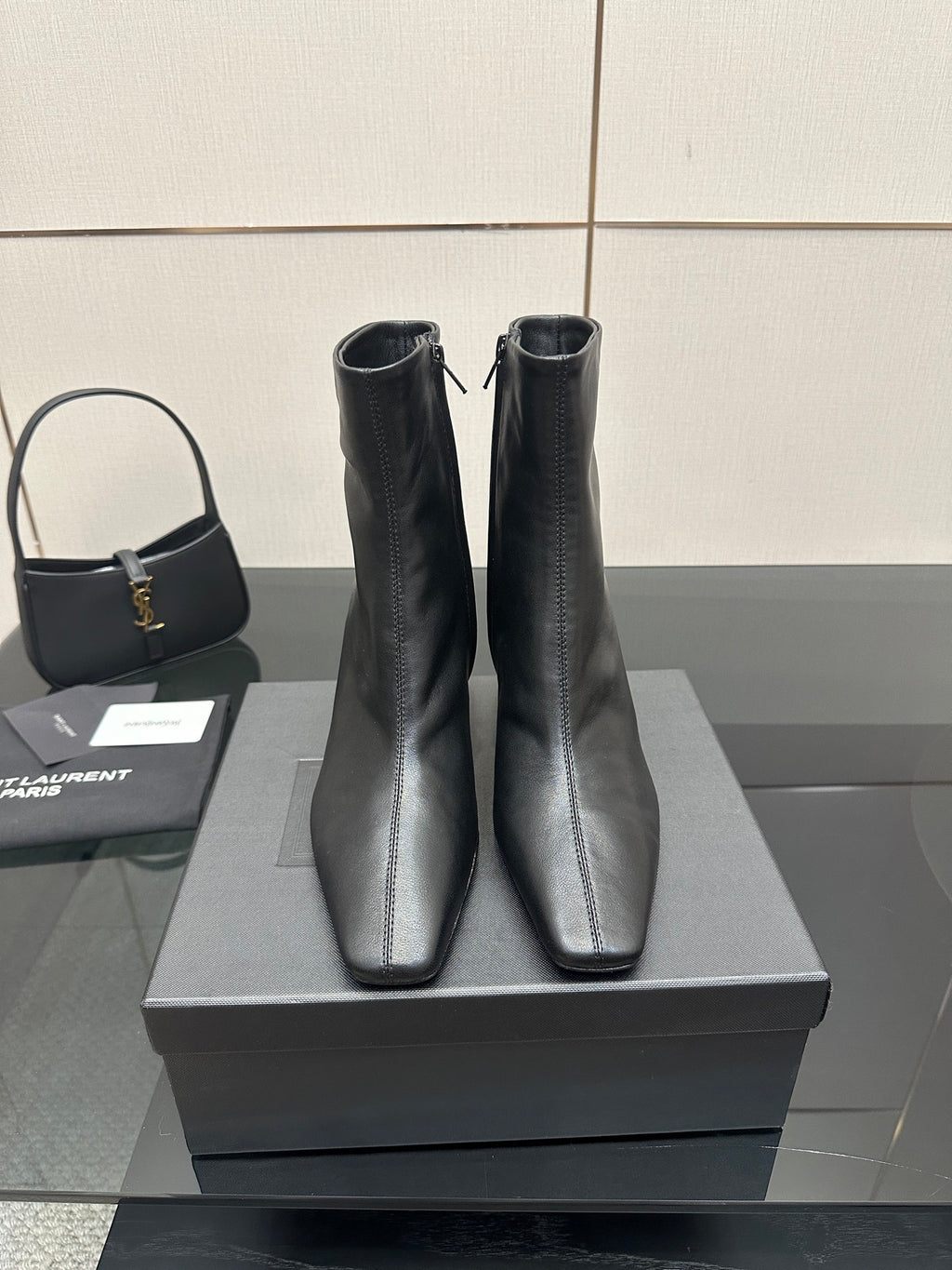 Pair of black heeled ankle boots on a display box