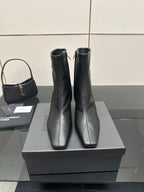 Pair of black heeled ankle boots on a display box