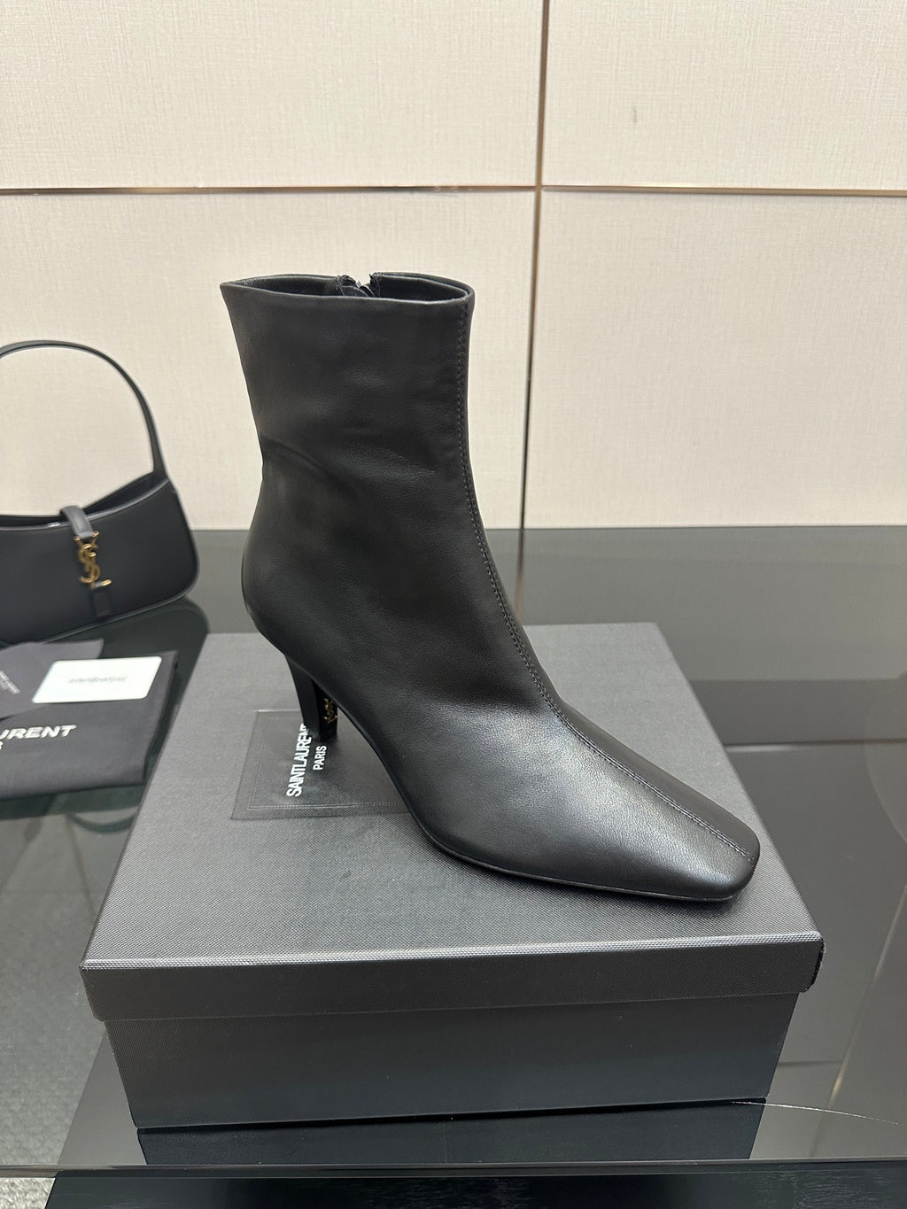Black ankle boot with block heel on a display box