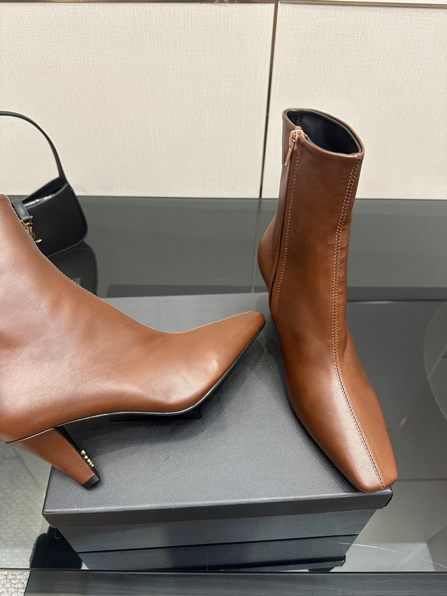 Women’s tan leather ankle boots, one close side view with pointed toe and slim heel