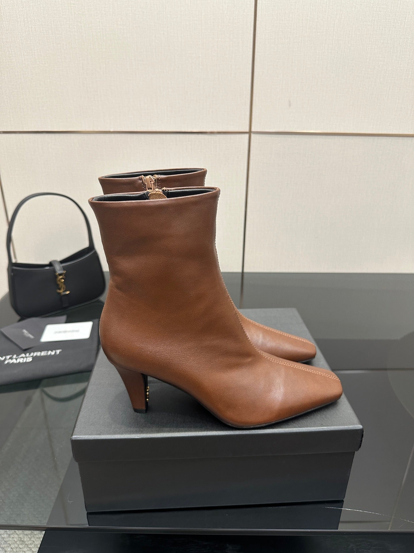 Women’s tan leather ankle boot on a box, pointed toe and slim block heel