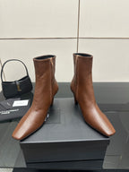 Women’s tan leather ankle boots with zip closure, pointed toe and slim heels