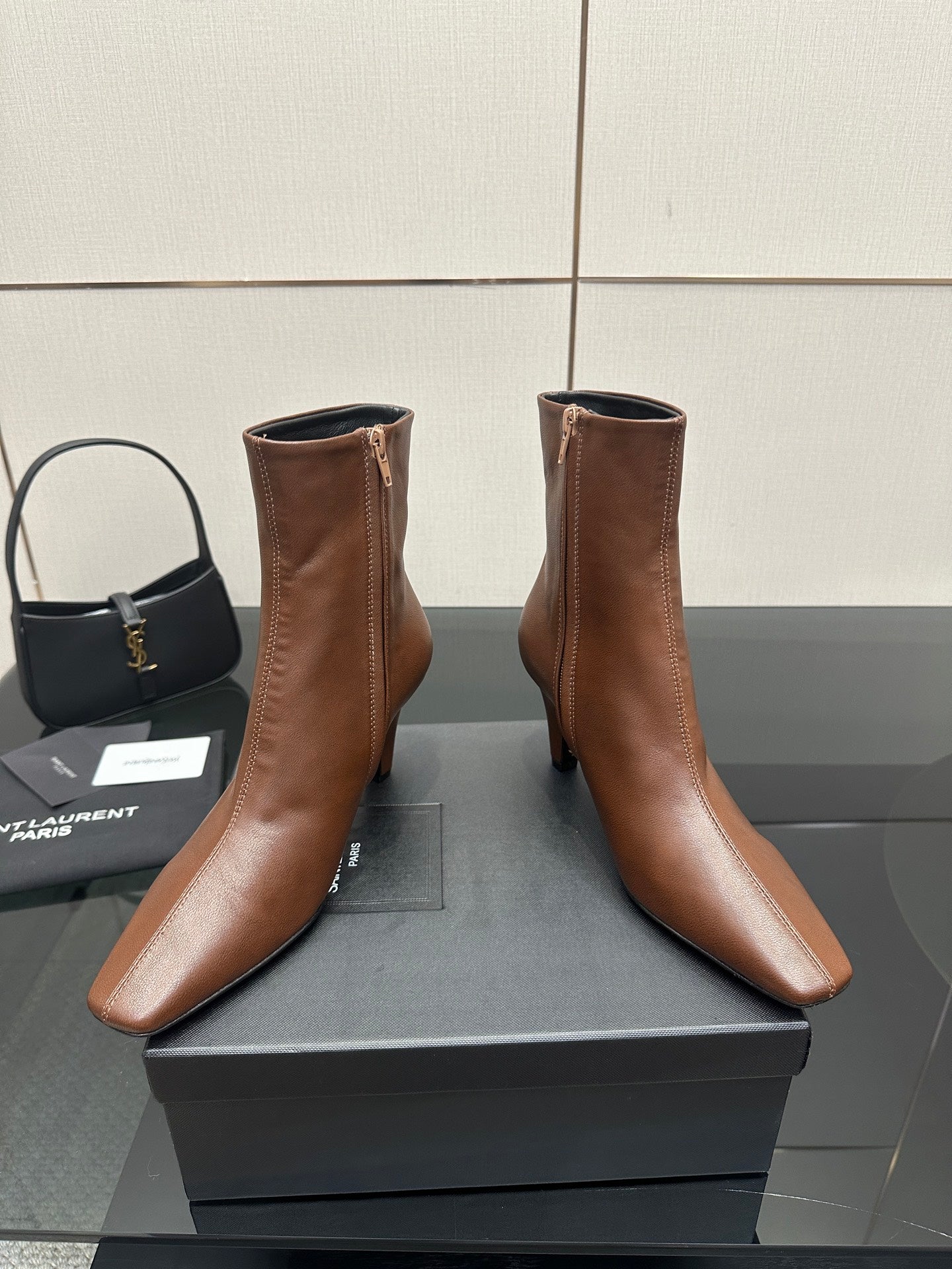 Women’s tan leather ankle boots with zip closure, pointed toe and slim heels