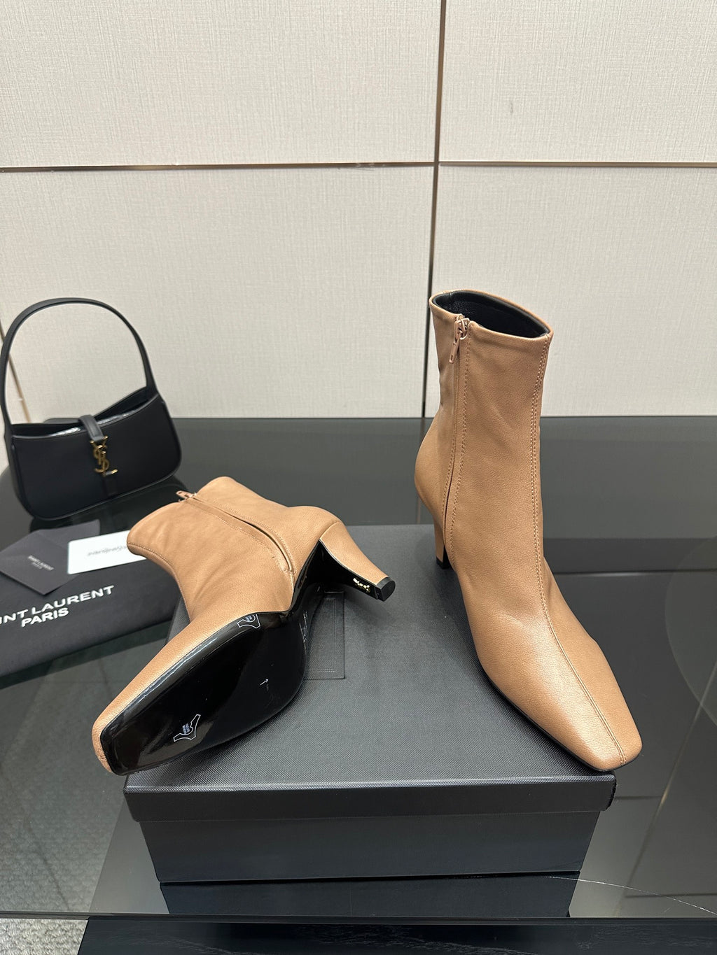 Beige ankle boot and matching heel mule-style shoe on black box