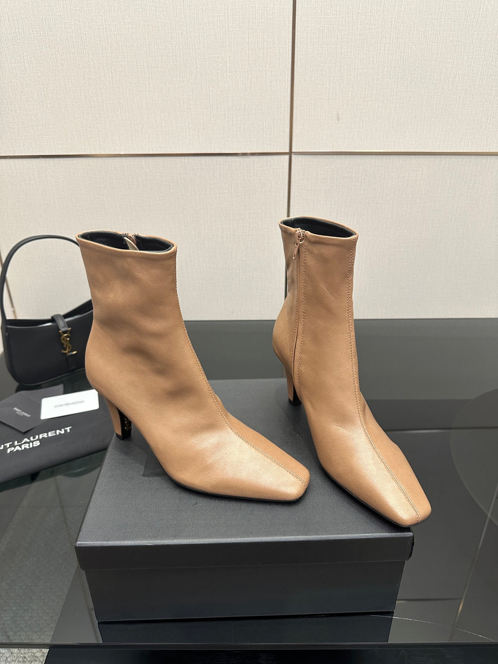 Beige pointed-toe ankle boots with slim high heel, angled pair on box