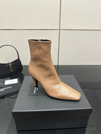 Beige pointed-toe ankle boot with slim heel, side view on black box