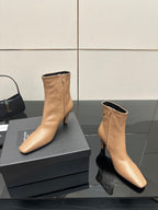 Beige ankle boots with pointed toe and slim heel, two angles on black box